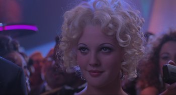 Movie still from “Batman Forever” (1995), directed by Joel Schumacher – A person with curly blonde hair; Close Up shot, Over the shoulder angle