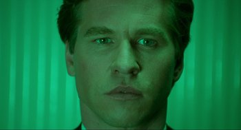 Movie still from “Batman Forever” (1995), directed by Joel Schumacher – A man's face in front of a green background; Close Up shot, Low angle