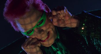 Movie still from “Batman Forever” (1995), directed by Joel Schumacher – A person with pink hair and green glasses; Close Up shot, Low angle