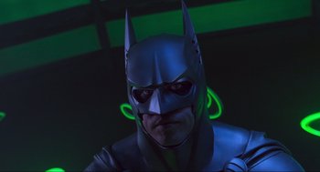 Movie still from “Batman Forever” (1995), directed by Joel Schumacher – A man dressed as a batman in front of a green light; Close Up shot, Low angle