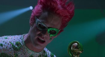 Movie still from “Batman Forever” (1995), directed by Joel Schumacher – A man with pink hair and a green mask; Close Up shot, Low angle