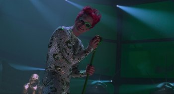 Movie still from “Batman Forever” (1995), directed by Joel Schumacher – A man with red hair is holding a cane; Medium shot, Low angle