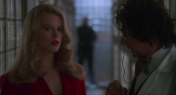 Movie still from “Batman Forever” (1995), directed by Joel Schumacher – A woman in a red jacket and a man in a red jacket; Close Up shot, Over the shoulder angle
