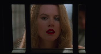 Movie still from “Batman Forever” (1995), directed by Joel Schumacher – A woman with red lipstick looking into a mirror; Close Up shot, Low angle