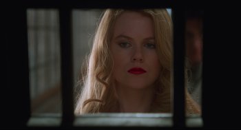 Movie still from “Batman Forever” (1995), directed by Joel Schumacher – A woman with red lipstick looking out a window; Close Up shot, Low angle