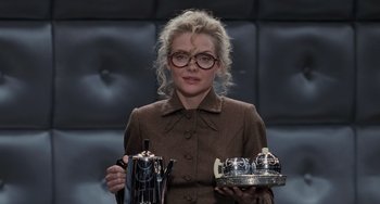Movie still from “Batman Returns” (1992), directed by Tim Burton – A woman holding a tea pot and a tea pot on a tray; Medium shot, Low angle