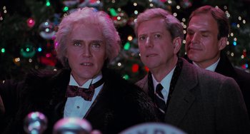 Movie still from “Batman Returns” (1992), directed by Tim Burton – A couple of men standing next to each other in front of a christmas tree; Close Up shot, Low angle