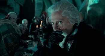 Movie still from “Batman Returns” (1992), directed by Tim Burton – An old man with white hair wearing a black jacket; Medium shot, Over the shoulder angle