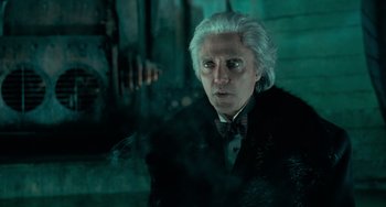 Movie still from “Batman Returns” (1992), directed by Tim Burton – A person wearing a suit and tie; Close Up shot, Low angle