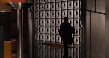 Movie still from “Batman Returns” (1992), directed by Tim Burton – A person walking in front of a wall of leather; Wide shot, Low angle