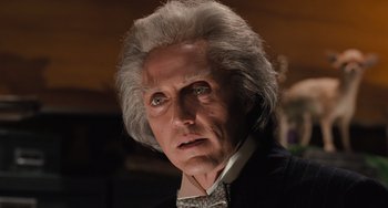 Movie still from “Batman Returns” (1992), directed by Tim Burton – An old man with a white hair and a black suit; Close Up shot, Low angle