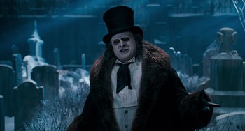 Movie still from “Batman Returns” (1992), directed by Tim Burton – A person wearing a top hat and a fur coat; Medium shot, Over the shoulder angle