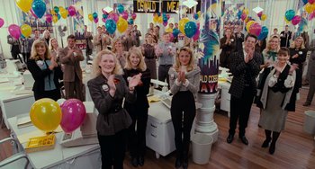 Movie still from “Batman Returns” (1992), directed by Tim Burton – A group of people standing in a room with balloons; Medium shot, High angle