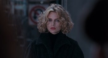 Movie still from “Batman Returns” (1992), directed by Tim Burton – A woman with blonde hair wearing a black coat; Close Up shot, Over the shoulder angle