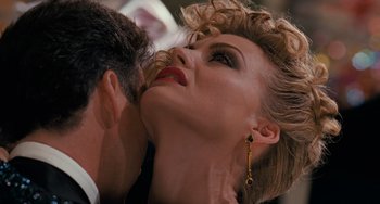 Movie still from “Batman Returns” (1992), directed by Tim Burton – A man and a woman are kissing in a room; Close Up shot, Over the shoulder angle