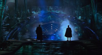 Movie still from “Batman & Robin” (1997), directed by Joel Schumacher – Two people in a dark room with a batman and robin statue; Wide shot, Low angle