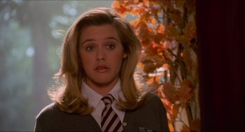 Movie still from “Batman & Robin” (1997), directed by Joel Schumacher – A woman with blonde hair wearing a suit and striped tie; Close Up shot, Low angle