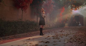 Movie still from “Batman & Robin” (1997), directed by Joel Schumacher – A woman standing on the sidewalk in the rain; Wide shot, Low angle