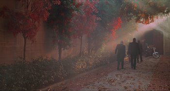 Movie still from “Batman & Robin” (1997), directed by Joel Schumacher – A man walking down a sidewalk near trees; Extreme Wide shot, High angle