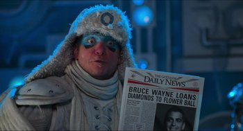 Movie still from “Batman & Robin” (1997), directed by Joel Schumacher – A man in a costume holding up a newspaper; Close Up shot, Low angle