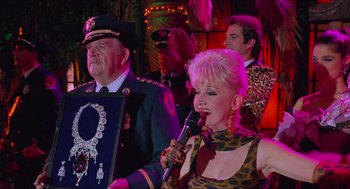 Movie still from “Batman & Robin” (1997), directed by Joel Schumacher – A man and a woman singing into a microphone; Close Up shot, Over the shoulder angle