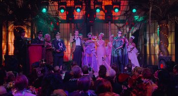 Movie still from “Batman & Robin” (1997), directed by Joel Schumacher – A group of people dressed in costumes on a stage; Wide shot, Low angle