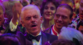 Movie still from “Batman & Robin” (1997), directed by Joel Schumacher – An older man in a suit and bow tie; Close Up shot, Over the shoulder angle