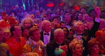 Movie still from “Batman & Robin” (1997), directed by Joel Schumacher – A group of people sitting in front of a crowd; Wide shot, High angle