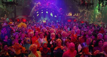 Movie still from “Batman & Robin” (1997), directed by Joel Schumacher – A large group of people wearing costumes in front of a stage; Extreme Wide shot, High angle