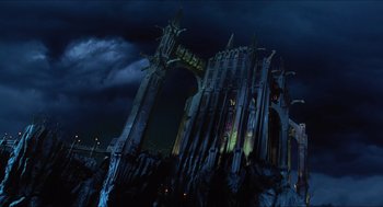 Movie still from “Batman & Robin” (1997), directed by Joel Schumacher – A large building with a large arch in front of a dark sky; Extreme Wide shot, Low angle