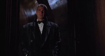 Movie still from “Batman & Robin” (1997), directed by Joel Schumacher – A man in a tuxedo standing in front of a door; Medium shot, Low angle