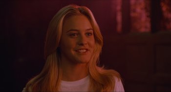 Movie still from “Batman & Robin” (1997), directed by Joel Schumacher – A beautiful blond haired woman smiling for the camera; Close Up shot, Over the shoulder angle