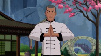 Movie still from “Batman: Soul of the Dragon” (2021), directed by Sam Liu – An animated man in a black and white outfit is praying; Medium shot, Low angle