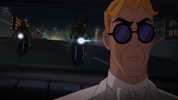 Movie still from “Batman: Soul of the Dragon” (2021), directed by Sam Liu – A man in a white shirt and bow tie with glasses; Close Up shot, Over the shoulder angle