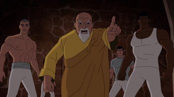Movie still from “Batman: Soul of the Dragon” (2021), directed by Sam Liu – An old man in a yellow robe pointing to the sky; Medium shot, Over the shoulder angle