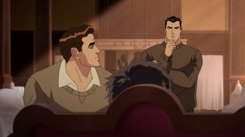 Movie still from “Batman: The Doom That Came to Gotham” (2023), directed by Sam Liu – Two men sitting in front of each other in front of a projector screen; Medium shot, Over the shoulder angle