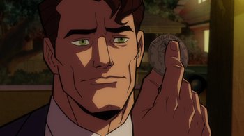 Movie still from “Batman: The Long Halloween” (2021), directed by Chris Palmer – A man holding a coin in front of his face; Close Up shot, Over the shoulder angle