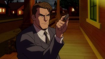 Movie still from “Batman: The Long Halloween” (2021), directed by Chris Palmer – A man in a suit and tie holding a cell phone in his hand; Close Up shot, Over the shoulder angle