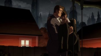 Movie still from “Batman: The Long Halloween” (2021), directed by Chris Palmer – A man and a woman standing next to each other in front of a building; Wide shot, High angle