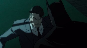 Movie still from “Batman: The Long Halloween” (2021), directed by Chris Palmer – A man wearing a suit and tie next to a bat; Medium shot, Over the shoulder angle