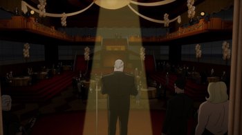 Movie still from “Batman: The Long Halloween” (2021), directed by Chris Palmer – A man standing in front of an audience in front of a microphone; Extreme Wide shot, High angle