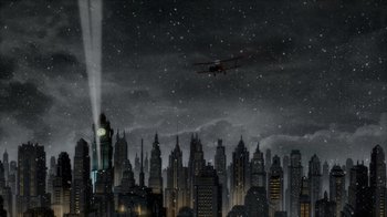 Movie still from “Batman: The Long Halloween” (2021), directed by Chris Palmer – An airplane flying over a large city at night; Extreme Wide shot, High angle