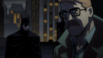 Movie still from “Batman: The Long Halloween” (2021), directed by Chris Palmer – A cartoon of a man and a batman in front of some buildings; Medium shot, Over the shoulder angle