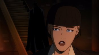 Movie still from “Batman: The Long Halloween” (2021), directed by Chris Palmer – A woman in a black jacket and a black hat; Close Up shot, Over the shoulder angle