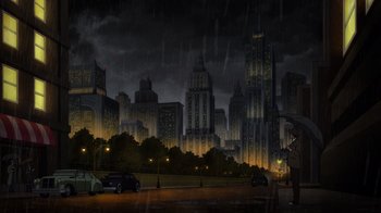 Movie still from “Batman: The Long Halloween, Part Two” (2021), directed by Chris Palmer – A rainy night in a city with a person holding an umbrella; Extreme Wide shot, High angle