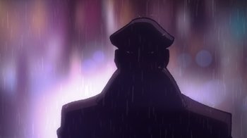Movie still from “Batman: The Long Halloween, Part Two” (2021), directed by Chris Palmer – A man with a hat is standing in the rain; Extreme Close Up shot, Low angle