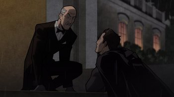 Movie still from “Batman: The Long Halloween, Part Two” (2021), directed by Chris Palmer – Two men in suits are sitting in the rain; Medium shot, Over the shoulder angle