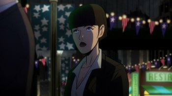 Movie still from “Batman: The Long Halloween, Part Two” (2021), directed by Chris Palmer – A woman in a black jacket is looking at the camera; Close Up shot, Over the shoulder angle