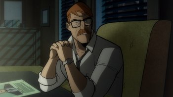 Movie still from “Batman: The Long Halloween, Part Two” (2021), directed by Chris Palmer – A man with a beard and glasses sitting in a chair; Medium shot, Over the shoulder angle