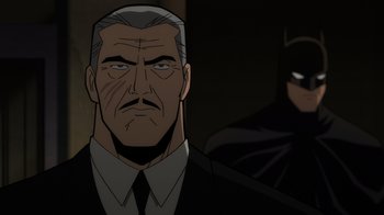 Movie still from “Batman: The Long Halloween, Part Two” (2021), directed by Chris Palmer – A person wearing a suit and tie; Close Up shot, Over the shoulder angle
